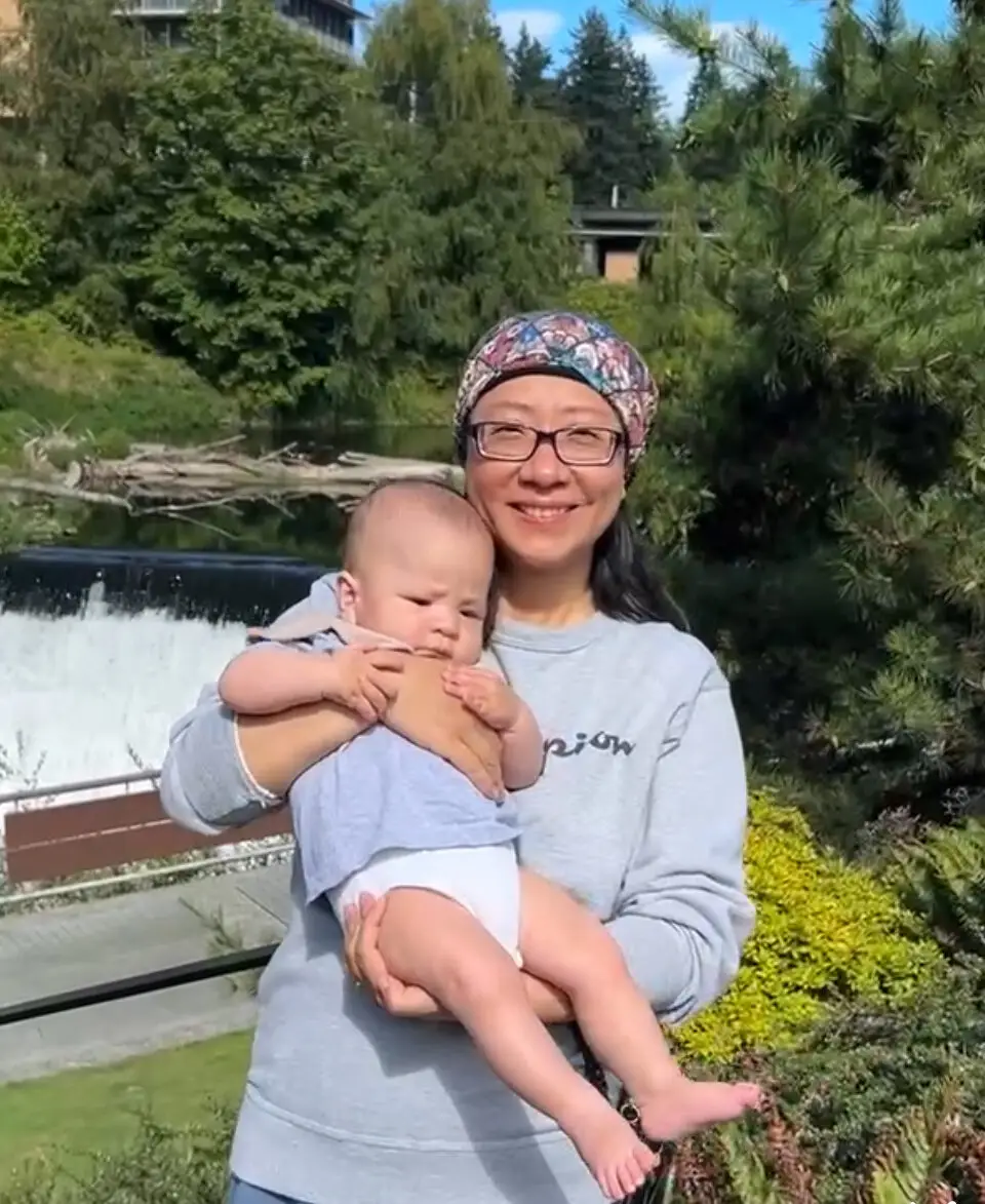 Student Yi Lund holds a baby.